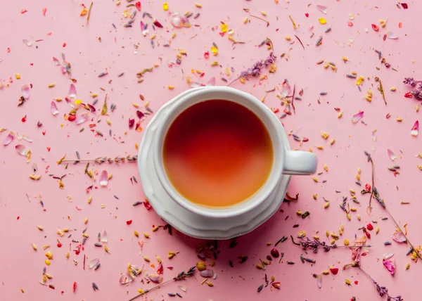ラベンダーの葉とピンクの背景の花びらのお茶のカップ ビューの上 — ストック写真