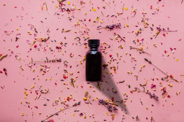Botella Vidrio Negro Con Pétalos Flores Pelado Lavanda Sobre Fondo —  Fotos de Stock