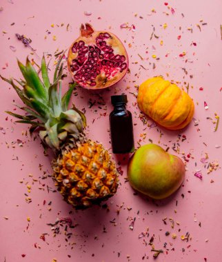 pealing ve nar, kabak, ananas ve elma lavanta çiçek yaprakları arka plan üzerinde siyah cam şişe