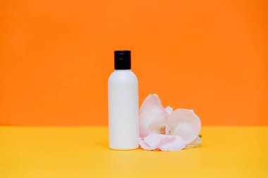 krem şişe ve beyaz gül 