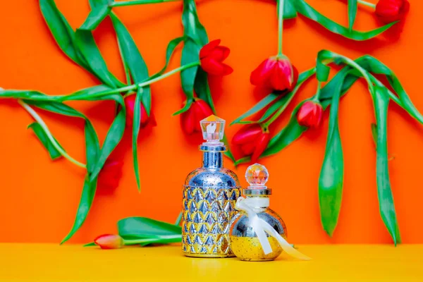 Frasco de perfume e tulipas — Fotografia de Stock