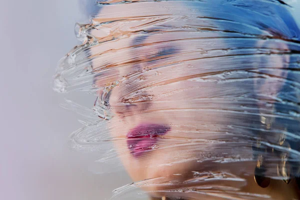 Rosto de mulher jovem com maquiagem e brinco com manchas de gel — Fotografia de Stock
