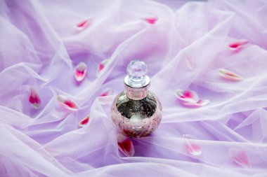 lale yaprakları ile arka planda mor tül içinde peduman şişe