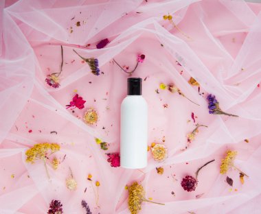 Pembe tül üzerinde peduman şişe ve Kuru çiçekler. Doğal ışık