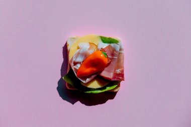 mor arka planda biber, jambon ve peynir ile sandviç. Yukarıdaki görünüm