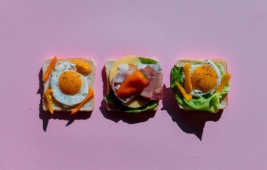 mor arka planda domates, Omlette, jambon ve peynir ile üç sandviç. Yukarıdaki görünüm