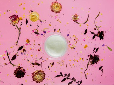 Pembe giriş üzerinde çiçekler ve cilt bakımı krem ile Kuru Bellis ot