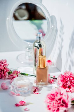 Ayna ve Dianthus çiçekler ile parfüm şişesi