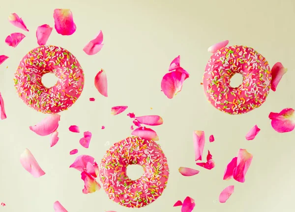 Volar en donas de cereza al aire con pétalos de rosa — Foto de Stock