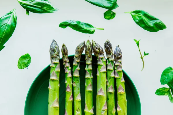 Espárragos verdes frescos y hojas de albahaca — Foto de Stock