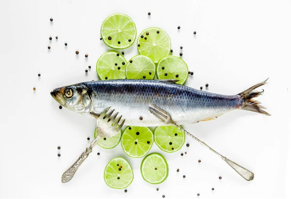 Fresh herring fish with lemons, peppers and forks — Stock Photo, Image