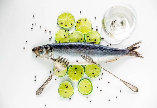 Fresh herring fish with lemons and peppers and wineglass — Stock Photo, Image