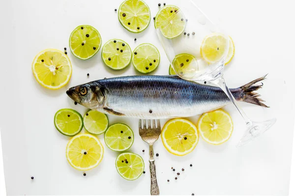 Fresh herring fish with lemons and peppers and wineglass — Stock Photo, Image