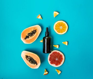 Mavi arka plan üzerinde ceeds ve siyah şişe ile Taze kesilmiş papaya