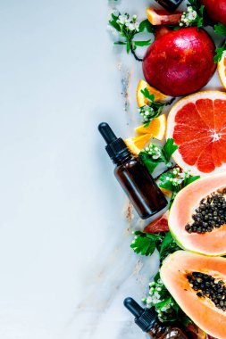 Siyah şişe yakınında ceeds, garnets, portakal ile Taze kesilmiş papaya 