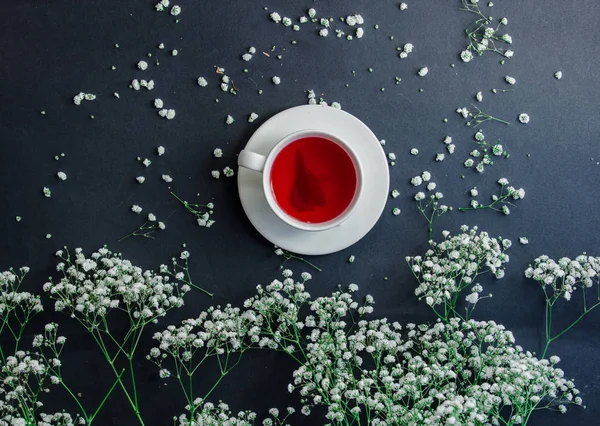 Xícara branca com chá vermelho e flores de Gypsophila paniculata — Fotografia de Stock