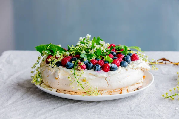 Прикрашений вершковий пиріг з гілками квітів і ягід на та — стокове фото