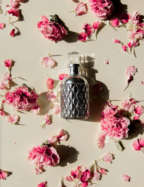 Dianthus bloemblaadjes en parfum fles met natuurlijke schaduwen — Stockfoto