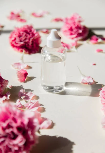 Пелюстки діантуса і пляшка парфумів з природними тінями — стокове фото