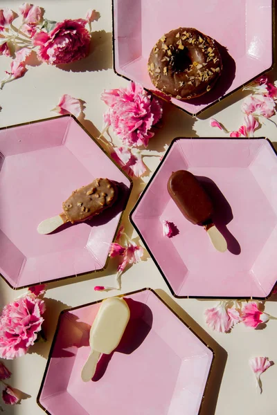 Donuts e sorvete em chapas com pétalas de dianthus — Fotografia de Stock