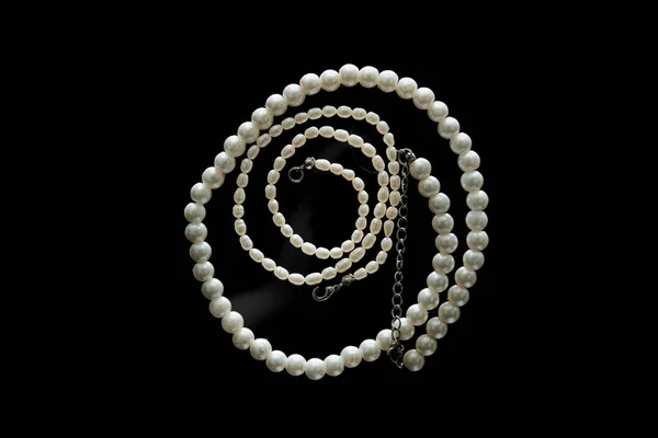 Halskette mit Perle spiralförmig auf Glastisch montiert. — Stockfoto