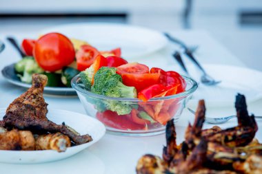 Izgara sığır eti ve tavuk, masada sebzeli. Yan görünüm