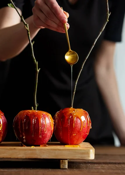 Mujer Verter Caramelo Sobre Manzanas Rojas —  Fotos de Stock