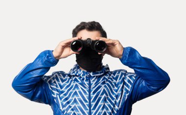 Beyaz arka planda dürbünlü yüz maskeli adam 