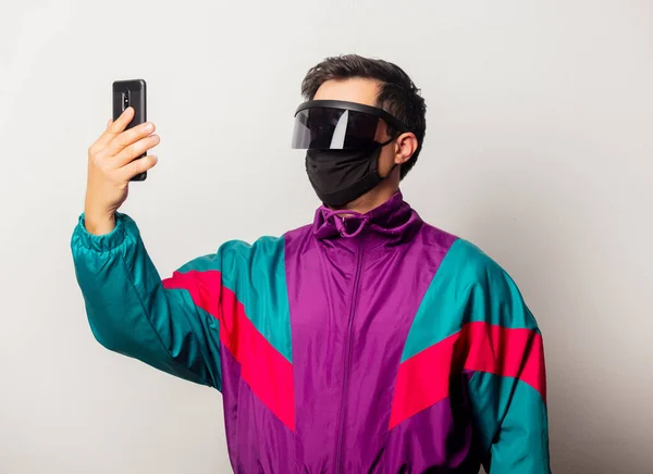 Style guy face mask and futuristic glassses with mobile phone on white background