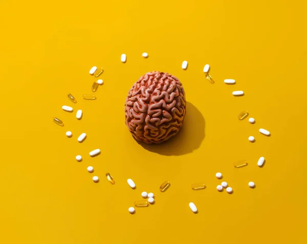 Man brain and pills around on yellow background