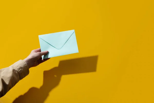 Woman Hand Holds Blue Envelope Yellow Background — Stock Photo, Image