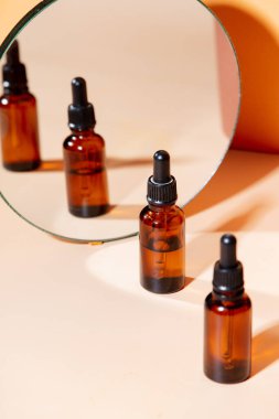 Kağıt arkaplanda aynanın yanında yağlı üç şişe.