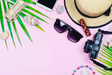 Yaz tatil seyahat aksesuarları pembe arka plan kavramı, kopya alanı ile üstten görünüm