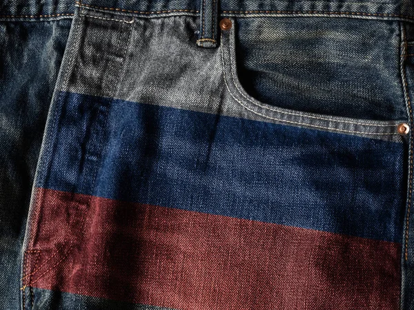 Russia flag On Jeans Denim Texture with pride word. The concept of Russia national flag on denim Jeans background. Russia Textile Industry Or Politics Concept.