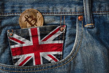 Birleşik Krallık (İngiltere) bayrağı veya Union Jack bayrak bayrak ile kot pantolon cebinde altın Bitcoin (Btc) cryptocurrency