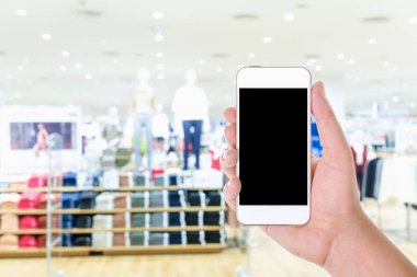 Adam el holding ve arka plan bulanık moda mağazası alışveriş merkezi ile boş ekran mobil akıllı telefon kullanma