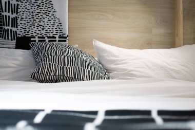 Siyah ve beyaz yastık ve minderler yatakta rahat yatak