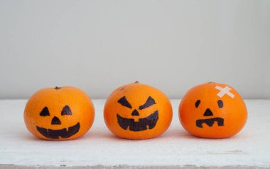 Ürkütücü yüzü kolay DIY dekorasyon için Halloween Festivali, kopya alanı ile beyaz ahşap üzerine kafa Pumpkins ile taze turuncu perili