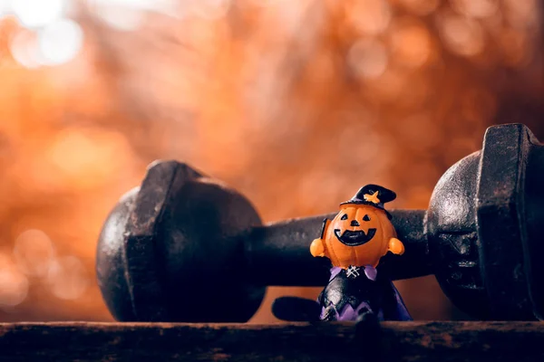 Cadılar Bayramı festivali yakın kadar Halloween Pumpkins bebek ve siyah demir dumbbell kafa. Fitness, sağlıklı aktif yaşam tarzı Halloweeen gün kavramı.
