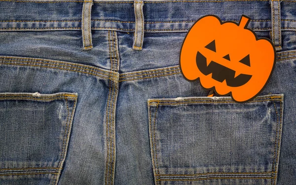 Happy Halloween day. Fashion background concept. Top View of Halloween pumpkin sign on denim jeans.