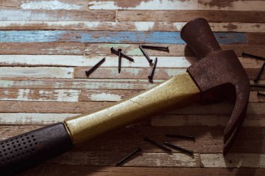 Paslı çivi grunge ahşap arka plan üzerinde çekiçle.