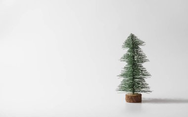 Minimalist kış tebrik kartı. Noel ve yeni yıl minyatür Noel ağacı kopya alanı metin için beyaz zemin üzerine. Kış tatil kutlama kavramı.