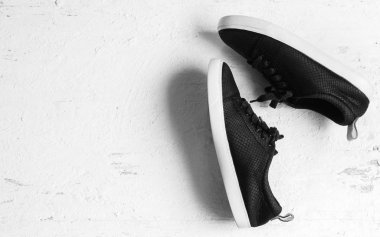 Grunge beyaz üzerine siyah spor ayakkabı ayakkabı çifti arka plan ağaç. Kopya alanı ile üstten görünüm.