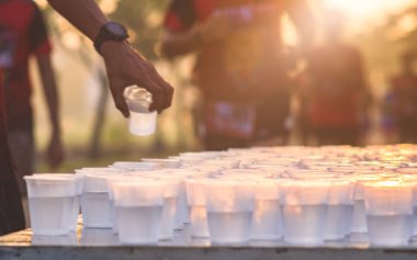 Maraton koşucusu gündoğumu, seçici odak, sığ Dof bir maraton yarışı hizmet noktasında bir su almak