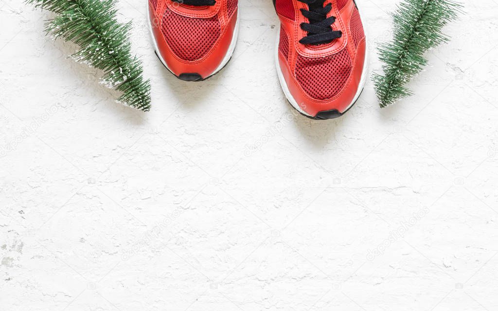 Christmas sport shoes flat lay composition with sneakers, christmas tree on grunge white wood  background. Merry Christmas and Happy new year background special for healthy lifestyle and sport.