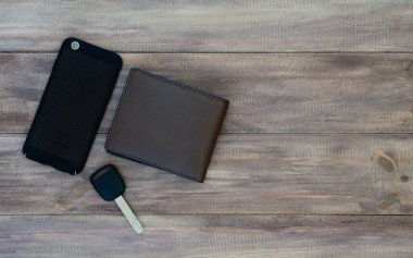 Adam en iyi görünümü ayarlama. M-cüzdan, Araba anahtarı ve ahşap arka plan üzerinde akıllı telefon. Kopya alanı ile üstten görünüm.