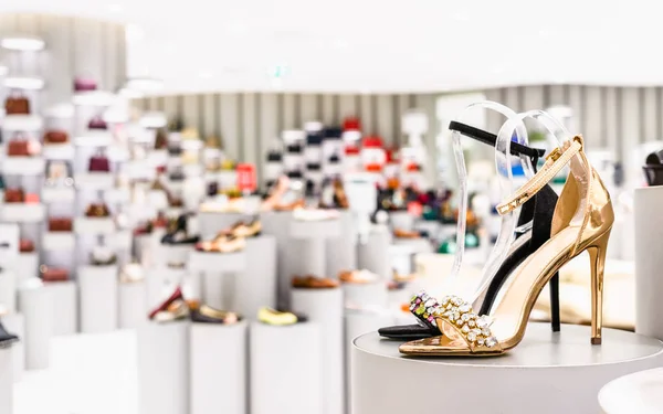 Close up of golden color and black color high heel shoes in a store