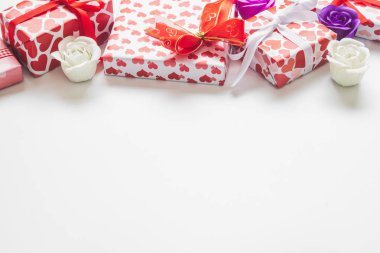 Hediye kutuları yürekleri ile Sevgililer günü arka plan şekli kağıt sarmalayıcı ve beyaz zemin üzerine gül.