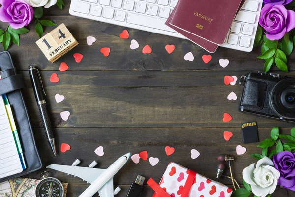 Valentine\'s Travel Plan concept. Pc keyboard, passport, camera, sd card, usb devices, notebook, roses, gift box and airplane model. Top view with copy space.