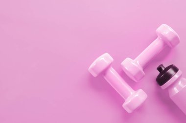 Fitness, egzersiz, sağlıklı yaşam Sevgililer günü arka plan kavramı çalışma. Pembe dumbell ve pembe pembe arka plan rengi su şişe.